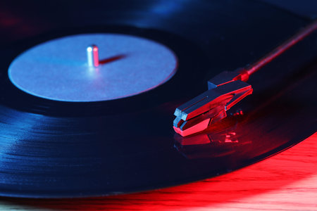 Turntable with vinyl record on wooden table, closeup