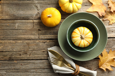 Beautiful table setting with autumn decor on wooden background, flat lay. Space for textの写真素材