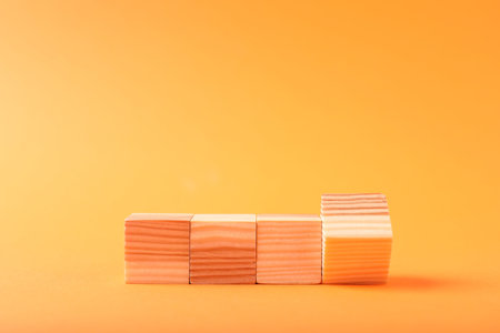Blank wooden cubes on orange background, space for text