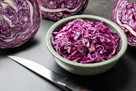 Cut red cabbage and knife on grey table, closeupの写真素材