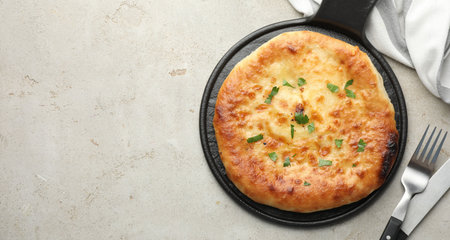 Delicious Megrelian khachapuri served on gray table, top view. Space for text