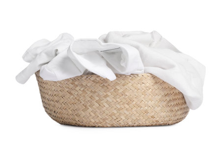 Wicker laundry basket full of clothes isolated on whiteの写真素材