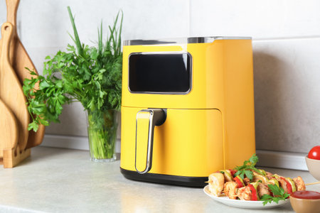 Tasty skewers with chicken, vegetables, parsley, and sauce on light countertopの写真素材