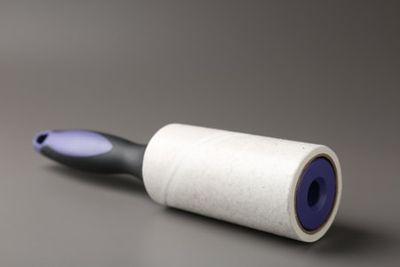 Lint roller with used sticky tape on gray background, closeupの写真素材