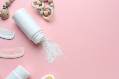 Bottle of talcum powder and baby accessories on pink background, flat lay. Space for textの写真素材