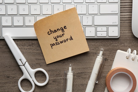 Note with phrase Change your password, keyboard and stationery on wooden desk, flat layの写真素材