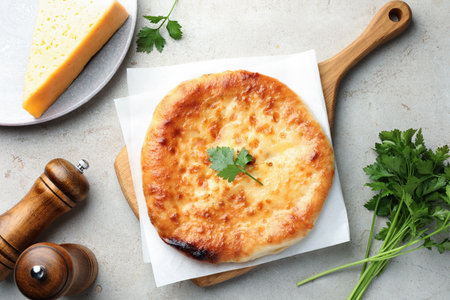 Delicious Megrelian khachapuri with ingredients on gray table, flat layの写真素材