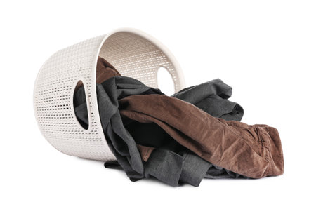 Overturned laundry basket with clothes isolated on whiteの写真素材