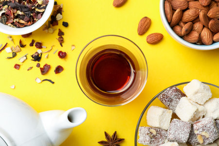 Flat lay composition with traditional Turkish tea, and sweets on yellow backgroundの写真素材