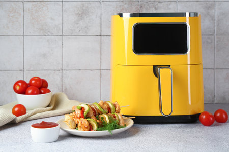 Tasty skewers with chicken, vegetables, sauce on light gray tableの写真素材