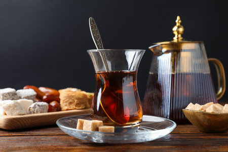 Traditional Turkish tea, brown sugar and sweets on wooden table, closeupの写真素材