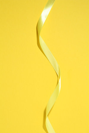 Beautiful ribbon on yellow background, top viewの写真素材