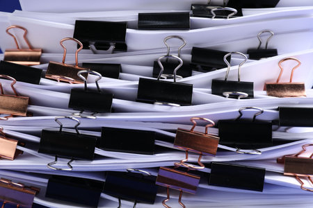 Many documents with binder clips on blue background, closeupの写真素材