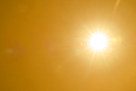 Bright sun in orange sky during hot summer weather.の写真素材