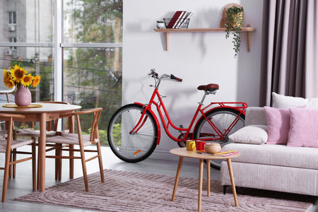 Wooden dining table with chairs, sofa and bicycle in room