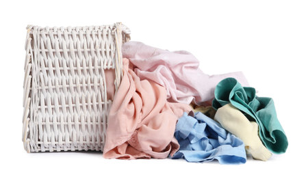 Overturned laundry basket with clothes isolated on whiteの写真素材