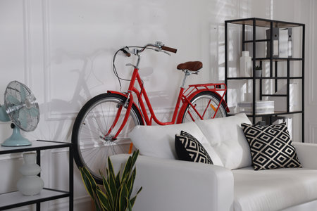 Red bicycle, sofa and houseplant in roomの写真素材