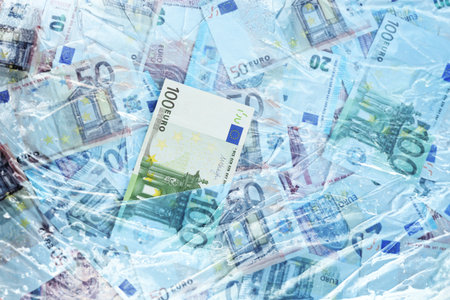 Money under ice. Many euro bills frozenの写真素材
