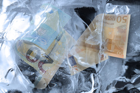 Bills in ice, closeup. Frozen paperの写真素材