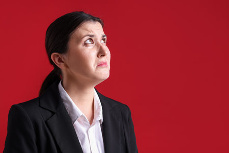 Businesswoman in suit on red background. Space for textの写真素材