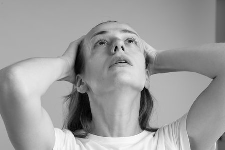 Woman crying on gray background, closeup. Black and white effectの写真素材