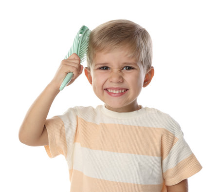 Little boy brushing his hair on white backgroundの写真素材