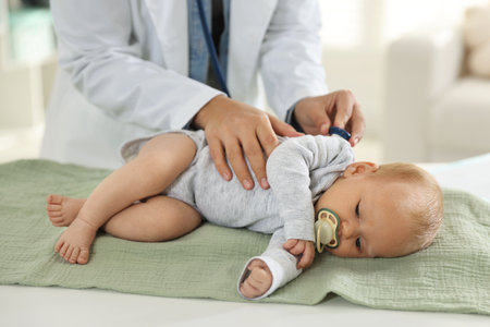 Pediatrician examining baby with stethoscope in hospital, closeupの写真素材