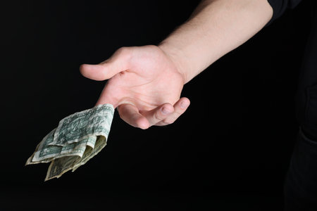 Man throwing money on black background, closeupの写真素材