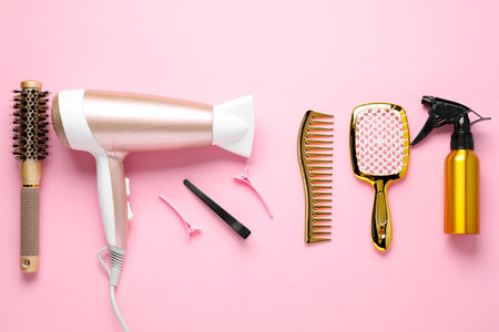 Different hair styling tools on pink background, flat layの写真素材