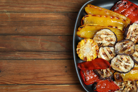Tasty grilled vegetables in pan on wooden table, top view. Space for textの写真素材