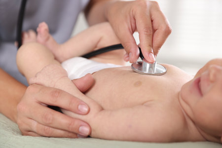 Doctor examining cute little child with stethoscope in hospital, closeup. Checking baby's healthの写真素材