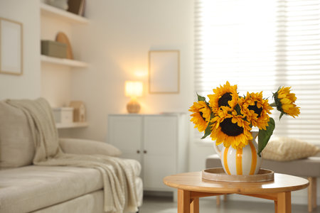 Beautiful sunflowers in vase on wooden table indoors, space for textの写真素材