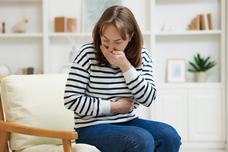 Woman suffering from stomach ache and nausea at home