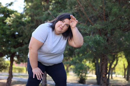 Tired woman after running in park. Space for textの写真素材