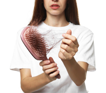 Woman with brush and lost hair on white background, closeup. Alopecia problemの写真素材