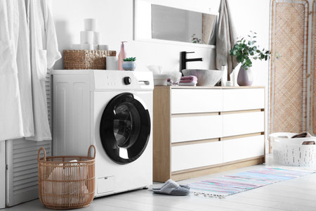 Washing machine and laundry basket near sink in bathroom. Interior designの写真素材