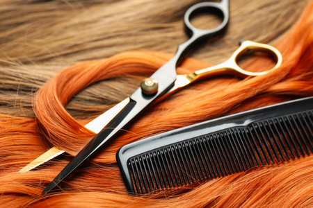 Scissors and comb on beautiful hair in different colors, closeupの写真素材