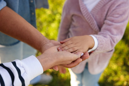 Parents and their daughters holding hands outdoors, closeup. Family bondingの写真素材
