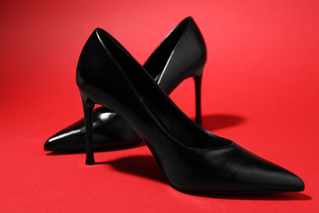Pair of stylish high heeled shoes on red background, closeupの写真素材