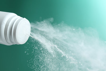 Pouring powder from plastic bottle on green background, closeupの写真素材