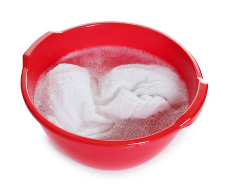 Plastic basin with towel and water isolated on whiteの写真素材