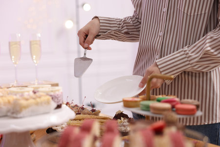 Guest taking delicious dessert from buffet table, closeupの写真素材