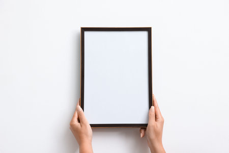 Blank frame on white wall, hanging closeup. Mockup for design