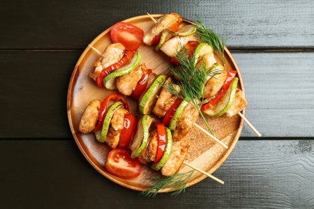 Skewers with grilled chicken and vegetables on wooden table, top viewの写真素材