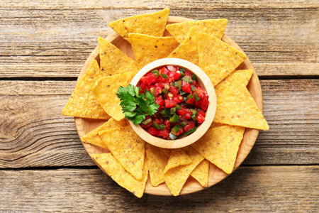 Tasty salsa with nachos on wooden table, top viewの写真素材