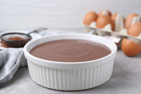 Raw chocolate dough in bowl on gray table, closeupの写真素材