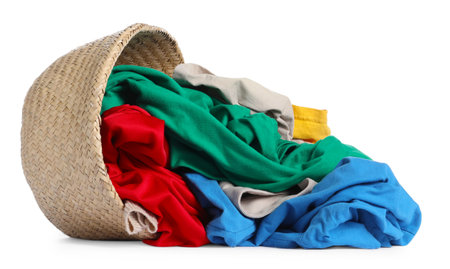 Overturned laundry basket with clothes isolated on whiteの写真素材