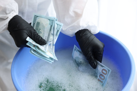 Money laundering. Woman washing dollar banknotes in basin indoors, closeupの写真素材