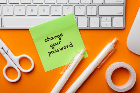 Note with phrase Change your password, keyboard and stationery on orange background, flat layの写真素材