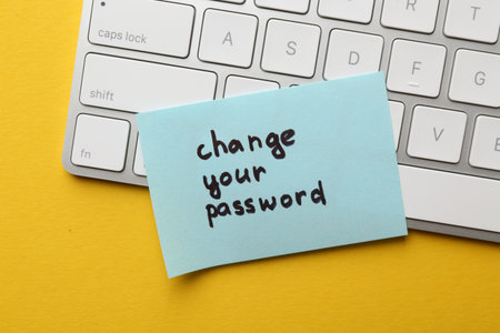 Note with phrase Change your password and keyboard on yellow background, top viewの写真素材